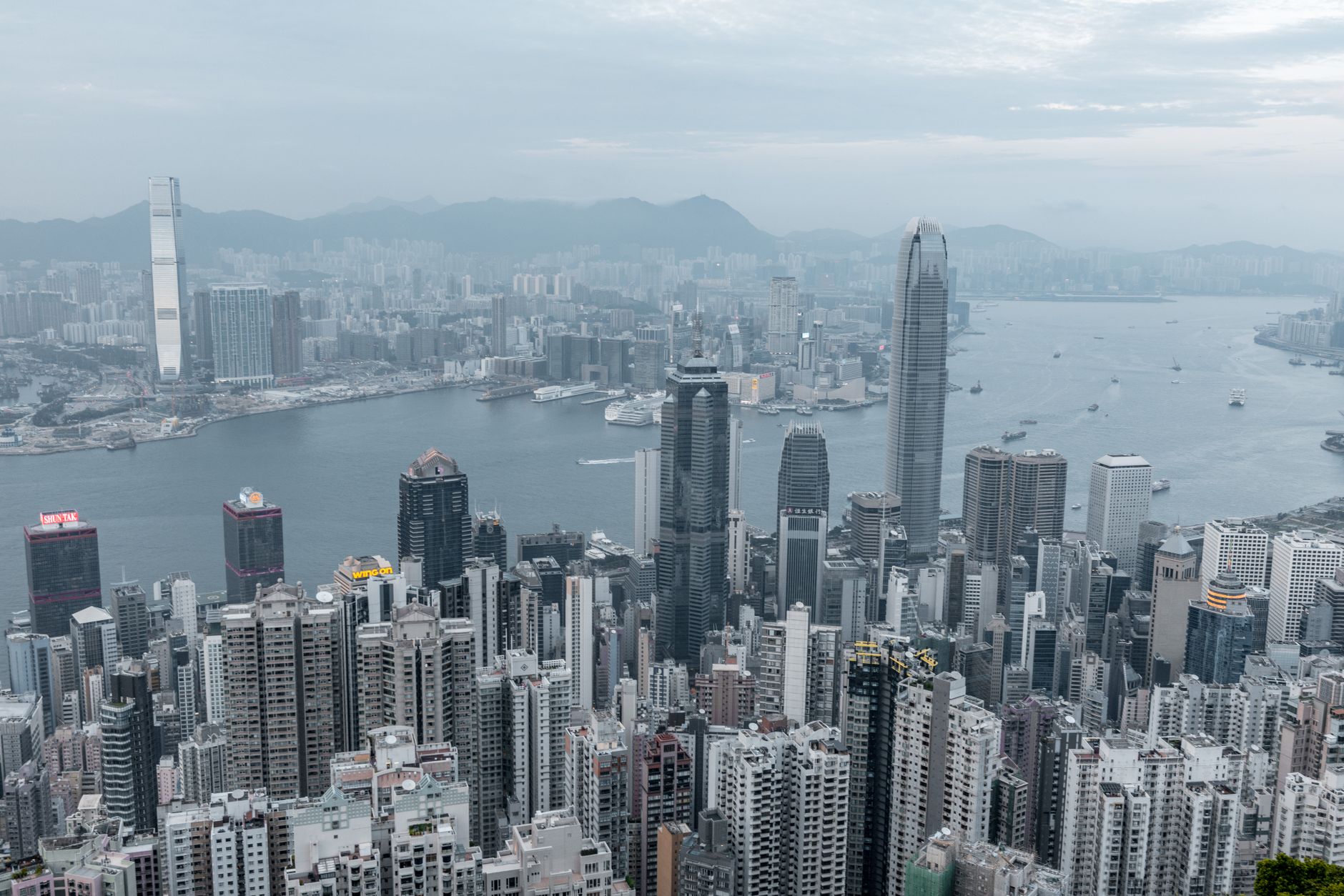 Vast cityscape of Hong Kong with modern skyscrapers and a river backdrop.